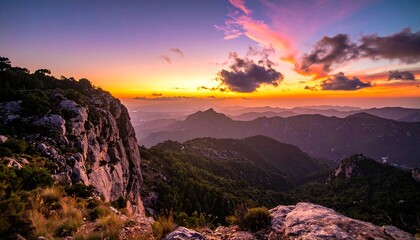 Mountain range silhouetted against a vibrant, fiery sunset