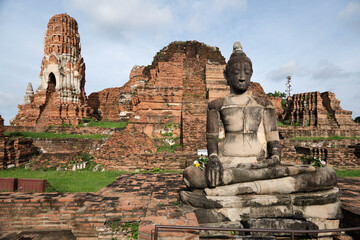 Ancient Buddha statue and stairs leading up to the ruins of the chedi at Wat Mahathat, Thailand