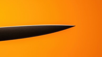 A black knife with a white handle against a bright orange background.