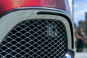 Close view of a shiny car grill showcasing modern design features and attention to detail