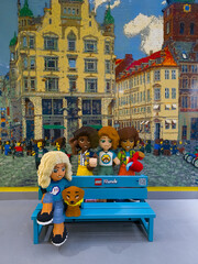 Obraz premium Copenhagen, Denmark - November 3, 2025: A bench with Lego Friends figurines at the showroom of the Lego store