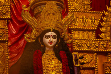 Obraz premium A beautifully crafted handmade colorful goddess durga idol decorated for Navratri, featuring vibrant traditional attire, intricate jewellery, and divine expressions at colorful pandal.