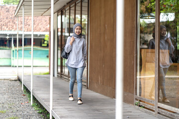 Indonesian Muslim woman walking outdoors with confidence