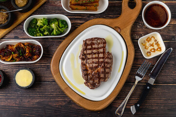 Tender grilled beef steak served with olive oil on plate