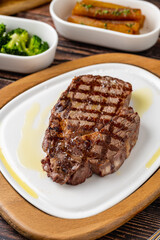 Tender grilled beef steak served with olive oil on plate
