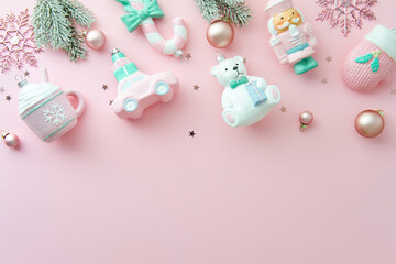 Christmas banner with glass pastel Christmas ornaments and fir branches on a light pink background.