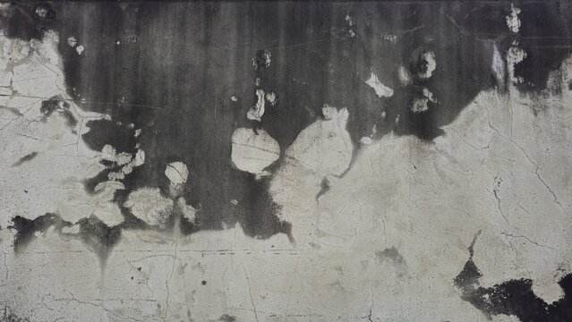 Weathered grey cement surface with visible cracks, dirt stains, and peeling paint. The material shows signs of significant wear and age.