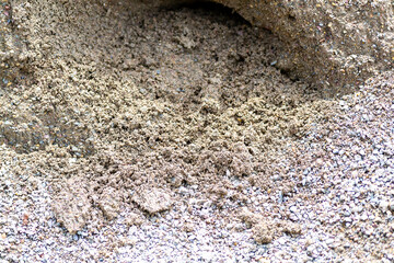 Construction site displaying freshly dug soil and gravel mixture during daytime work hours in a local area