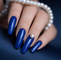 Cobalt blue manicure with one pearl accent nail, glossy finish, cool-tone aesthetic, clean composition, long coffin nails, crisp studio