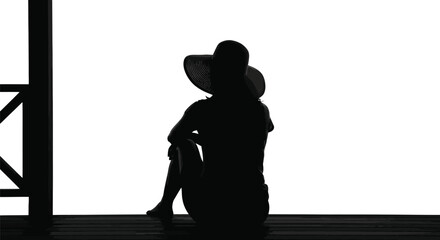 Silhouette of a person wearing a hat while sitting 