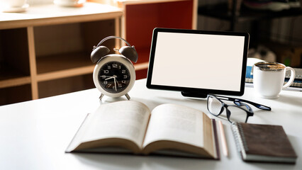 close up shot, alarm clock and digital tablet with open book to study and learning on table, Increasing knowledge concept via online system