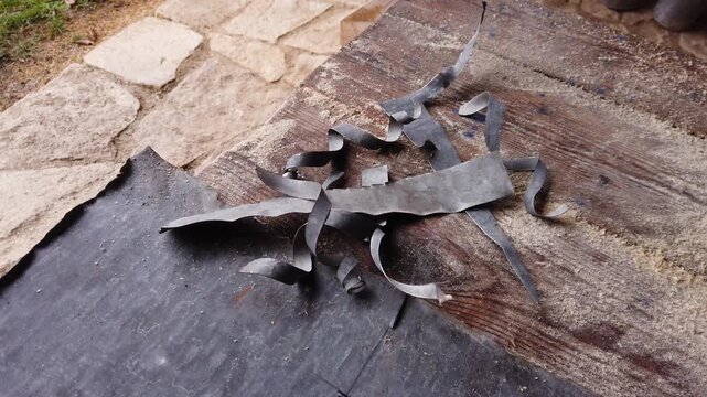 Still video of pieces of sheet metal after cutting on a wooden background