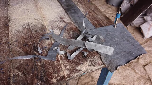 Still video of pieces of sheet metal after cutting on a wooden background