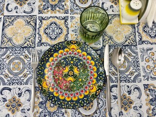 Vibrantly colored plate with mandala pattern set on tablecloth