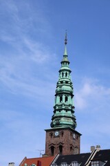 Obraz premium Copper spire and brick tower of the former St. Nicholas Church (Nikolaj Kirke), Copenhagen, Denmark