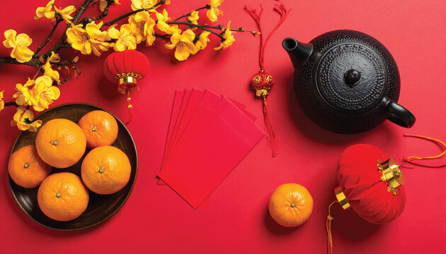 chinese new year flat lay composition with teapot red envelopes oranges lanterns golden flowers on red background