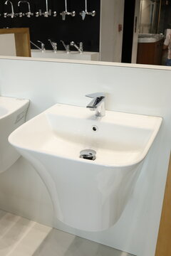 Modern white semi-recessed bathroom sink with chrome faucet display