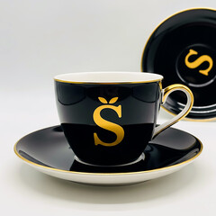 Black teacup and saucer with gold letter S and trim image