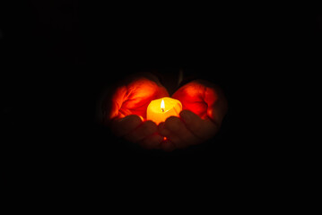 Religious concept. Burning candle in the mans hands on a dark background. Religious concept....