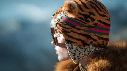 A fashionably dressed woman wearing a tiger-print hat with ears, oversized round sunglasses, and a fur coat. - Powered by Adobe