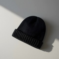 Black ribbed knit beanie hat, a warm and stylish headwear accessory for cold weather fashion on white