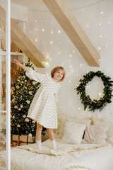 Joyful Child Jumping on Bed in Cozy Christmas Decorated Room