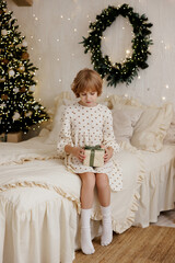 Smiling Child Opening a Gift in a Cozy Christmas Bedroom
