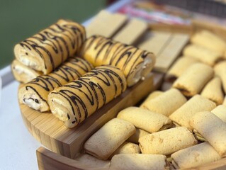 Assorted cookies displayed on a table at an outdoor event. Sweet pastries served at a festive gathering with people blurred in the background, perfect for food and lifestyle themes.