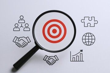 Strategic Focus: Magnifying Glass on Target with Business Icons for Goal Achievement and Success