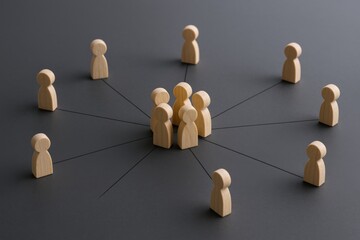 Obraz premium Wooden Figures Representing Network Connection and Communication, Illustrating Business Relationships and Social Interaction on a Dark Background