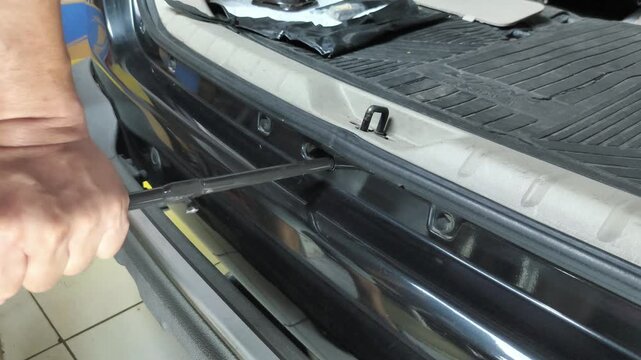 Rotate the winch to remove the spare tire from the storage area under the rear of the car to change a flat tire.