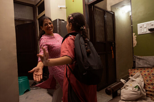 A joyful reunion as the school-going daughter runs into her mother's arms