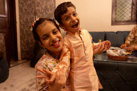 Two cheerful siblings pose happily for the camera during the festive celebration