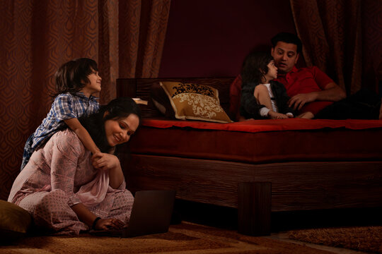 Parents spending fun times with their kids in bedroom