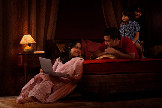 Parents spending fun times with their kids in bedroom