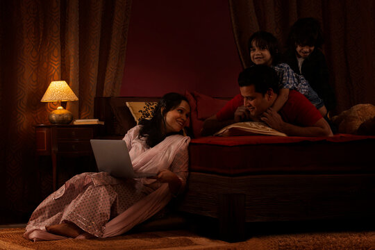 Parents spending fun times with their kids in bedroom