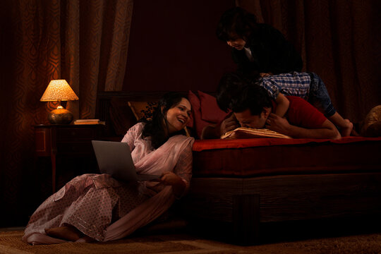 Parents spending fun times with their kids in bedroom