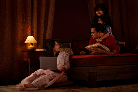 Parents spending fun times with their kids in bedroom