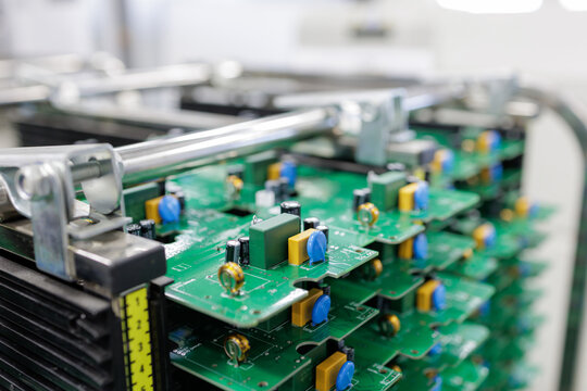 Stack of assembled printed circuit boards in rack at modern electronics factory