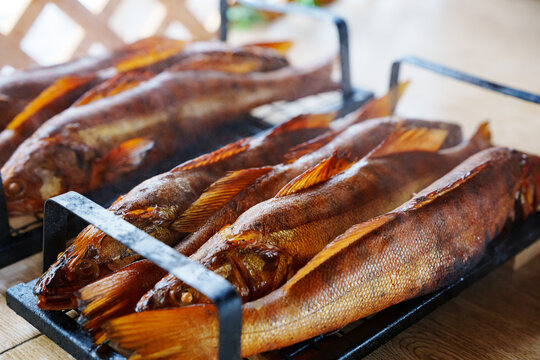 Grilled fish served on a wooden table at outdoor setting