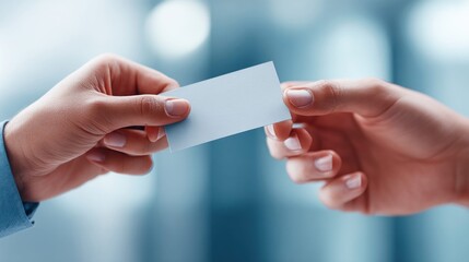 Hands are exchanging a blank business card, promoting networking and professional relationships.