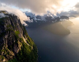Dramatic aerial view of a mountain range next to water during the sunset