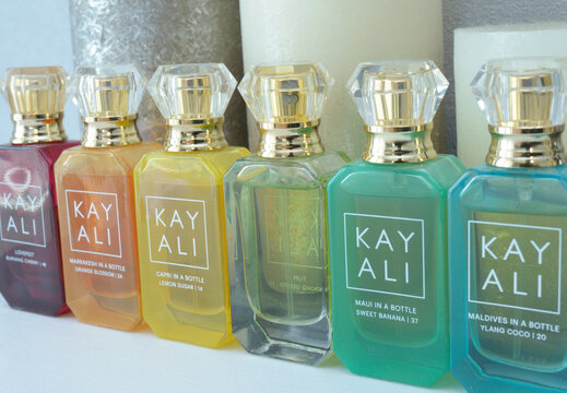 Perfume Kay Ali in bottles placed on a dressing table in front of candles.