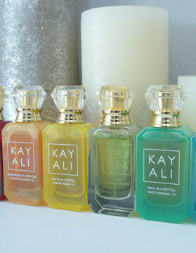 Perfume Kay Ali in bottles placed on a dressing table in front of candles.