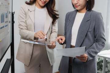 Businesswomen collaborating while discussing data charts at office