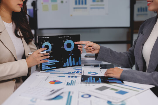 Businesswomen analyzing financial data on tablet screen