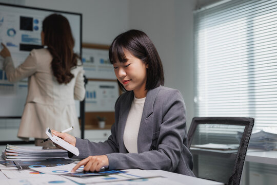 Asian businesswoman analyzing financial data during office meeting - Powered by Adobe