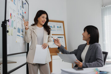 Businesswomen discussing financial data during office presentation meeting