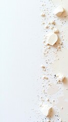 Scattered white powder and dark specks on a plain white background, abstract composition with soft light.