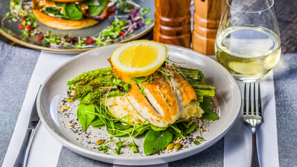 A succulent Barramundi fillet, served with tender asparagus spears and creamy mashed potato. Garnished with fresh basil leaves and finished with a slice of lemon on top.